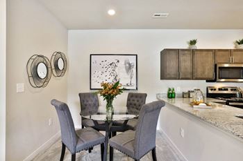 a dining room with a table and chairs and a kitchen  at Aventura at Hawk Ridge, Lake St Louis, Missouri